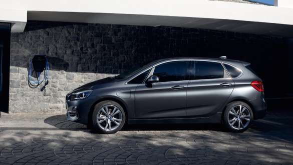 Plug-in хибрид BMW 225xe Актив Турър F45 три четвърти изглед отстрани Plug-in хибрид BMW 225xe Актив Турър F45 три четвърти изглед отстрани пред сграда
