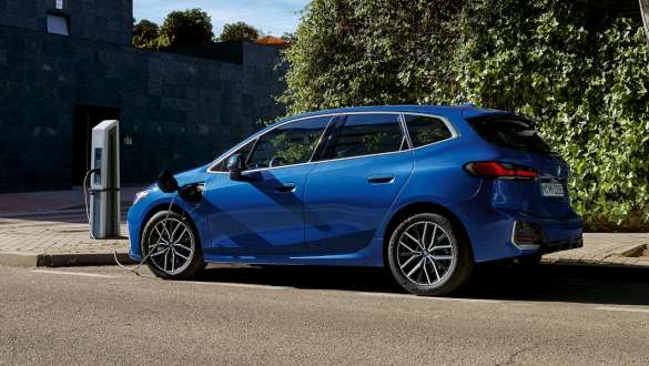 BMW Серия 2 Актив Турър 230e Plug-in хибрид U06 2021 на зарядна станция BMW Серия 2 Актив Турър 230e Plug-in хибрид U06 2021 M Portimao Blue metallic три четвърти изглед отстрани на зарядна станция