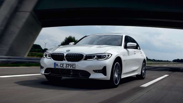 Plug-in хибрид BMW Серия 3 Седан 2021 G20 три четвърти изглед отпред в движение Plug-in хибрид BMW Серия 3 Седан 2021 G20 три четвърти изглед отпред в движение на пътя