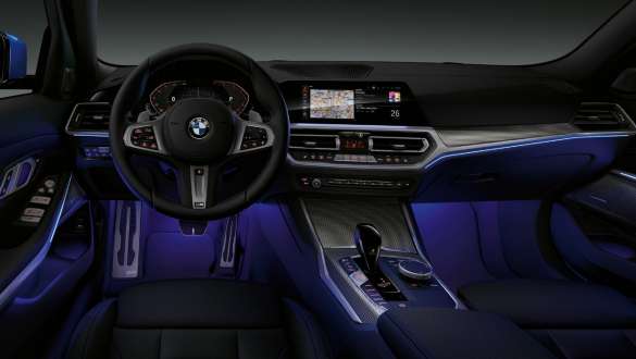 BMW 3 Series Седан, Вътрешно осветление. Преден изглед на кокпита на шофьора на BMW Серия 3 Седан със светло синьо осветление в зоната за краката.
