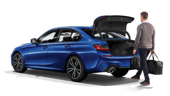 BMW Серия 3 Седан (G20), Автоматично отваряне на багажника Три четвърти изглед отзад на паркирано BMW Серия 3 Седан (G20) с водач, който отваря автоматично задния капак с крака си.
