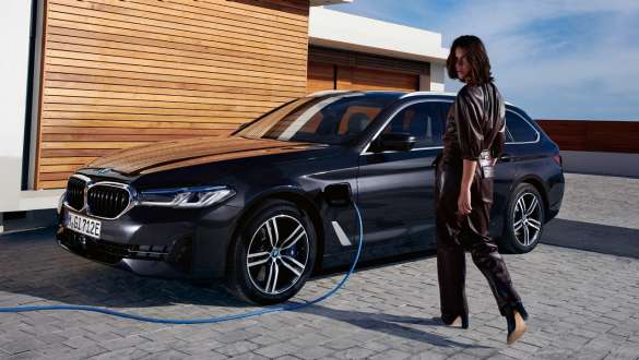 Plug-in хибрид BMW Серия 5 Туринг 2021 G31 LCI три четвърти изглед отстрани при зареждане Plug-in хибрид BMW Серия 5 Туринг 2021 G31 LCI три четвърти изглед отстрани при зареждане с модел