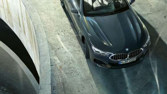 BMW M850i xDrive Dravit Grey metallic, в движение, предна част от пепспектива „птичи поглед“, Интегрално активно кормилно управление. BMW M850i xDrive Dravit Grey metallic, в движение, предна част от пепспектива „птичи поглед“, Интегрално активно кормилно управление.