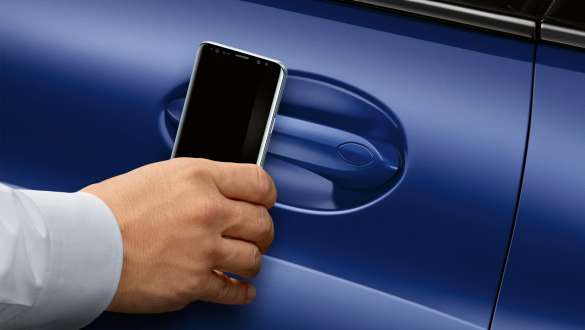 BMW Digital Key BMW BMW Серия 8 Купе G15 LCI Facelift 2022 Ръка държи смартфон до вратата на автомобила BMW Серия 8 Купе G15 M Portimao Blau metallic LCI Facelift 2022