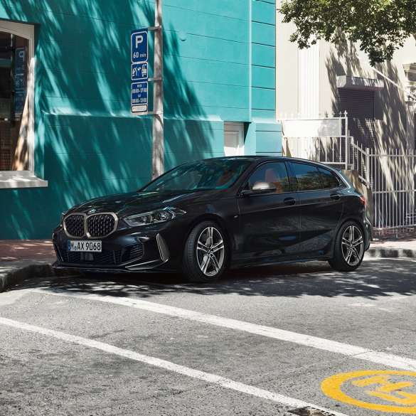 BMW M135i xDrive, три четвърти изглед отстрани BMW M135i xDrive в Black Sapphire metallic, три четвърти изглед отстрани, паркирано.