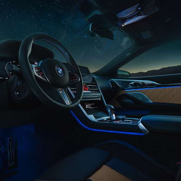BMW M8 Competition Купе, кокпит. BMW M8 Competition Купе, кокпит през нощта с М кожен волан и синьо вътрешно осветление.
