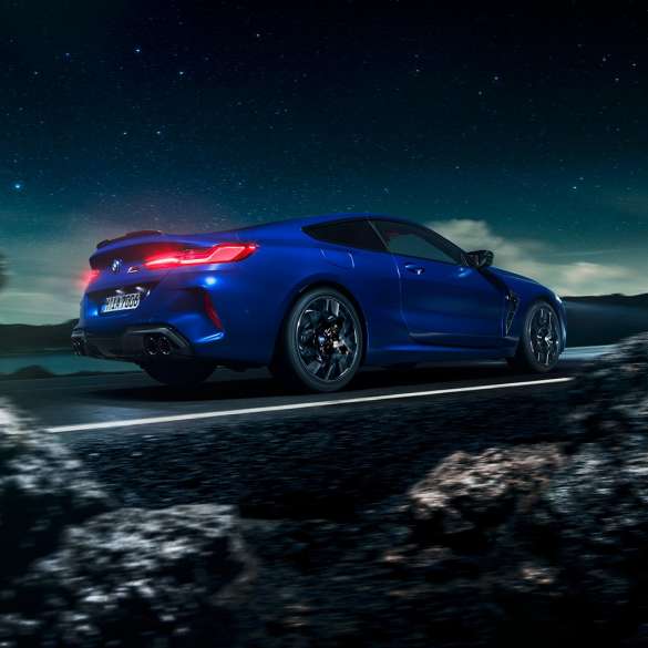 BMW M8 Competition Купе, три четвърти изглед отстрани. BMW M8 Competition Купе в Marina Bay Blue metallic, три четвърти изглед отстрани, в движение.