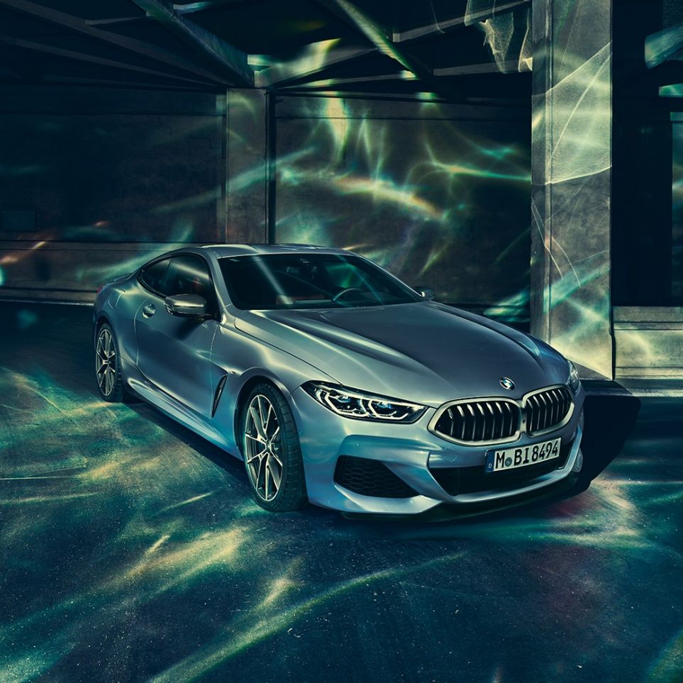 BMW M850i xDrive Купе, три четвърти изглед отпред отляво. BMW M850i xDrive Купе в Barcelona Blue metallic, три четвърти изглед отпред отляво, в покой пред сграда