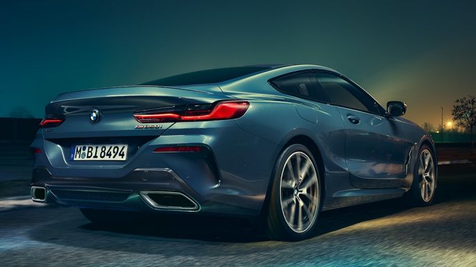 BMW M850i xDrive Купе, изглед отзад. BMW M850i xDrive Купе в Barcelona Blue metallic, изглед отзад, в движение през нощта.
