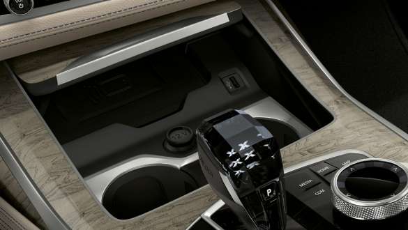 Темперираните поставки за чаши на BMW X7 M Автомобил BMW X7 M Автомобил, интериор, снимка отблизо на средната конзола с фокус върху темперираните поставки за чаши