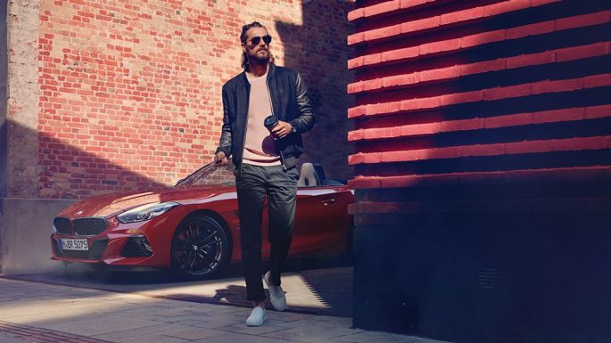 BMW Z4 Роудстър в странична улица Мъж на странична улица пред BMW Z4 Роудстър