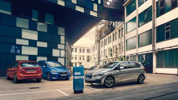 BMW хибридни автомобили на зарядна станция пред сграда BMW обществено зареждане BMW хибридни автомобили на зарядна станция пред сграда