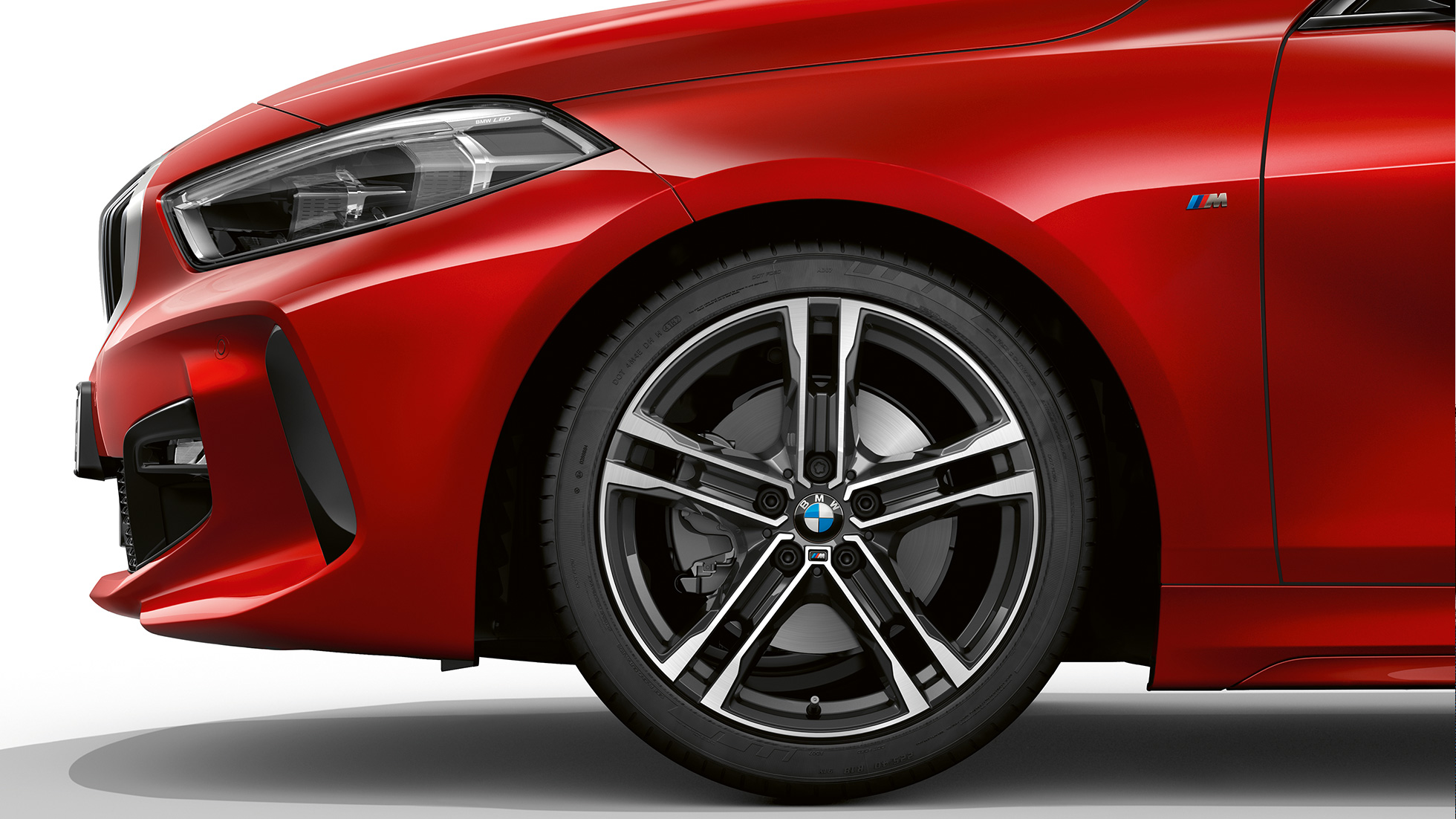 BMW Серия 1 Модел M Sport, страничен изглед отпред. BMW Серия 1 Модел M Sport в цвят Melbourne Red metallic, страничен изглед отпред със 17-инчови алуминиеви джанти с двойни спици 550 M Bicolor.