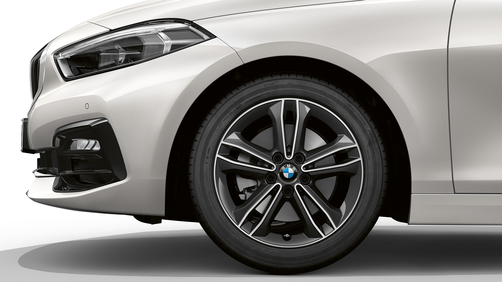 17-инчови алуминиеви джанти с двойни спици 549. BMW Серия 1 Модел Sport Line в цвят Mineral White metallic, страничен изглед отпред със 17-инчови алуминиеви джанти с двойни спици 549.