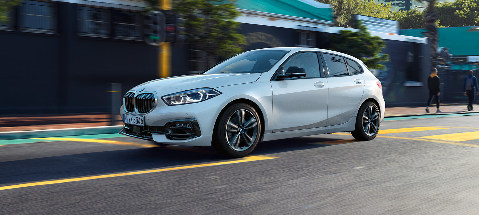 BMW Серия 1 Модел Sport Line, три четвърти изглед отстрани. BMW Серия 1 Модел Sport Line в цвят Mineral White metallic, три четвърти изглед отстрани, в движение.