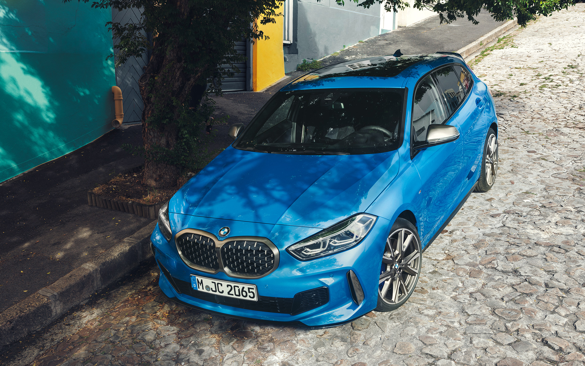 BMW Серия 1 M135i F40 на пътя BMW Серия 1 M135i F40 в Misano Blue metallic, три четвърти изглед отпред, паркирано на пътя от перспектива птичи поглед