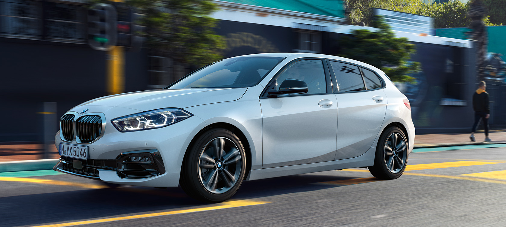 BMW Серия 1 F40 модел Sport Line три четвърти изглед отстрани в движение BMW Серия 1 F40 модел Sport Line Mineral White metallic три четвърти изглед отстрани в движение