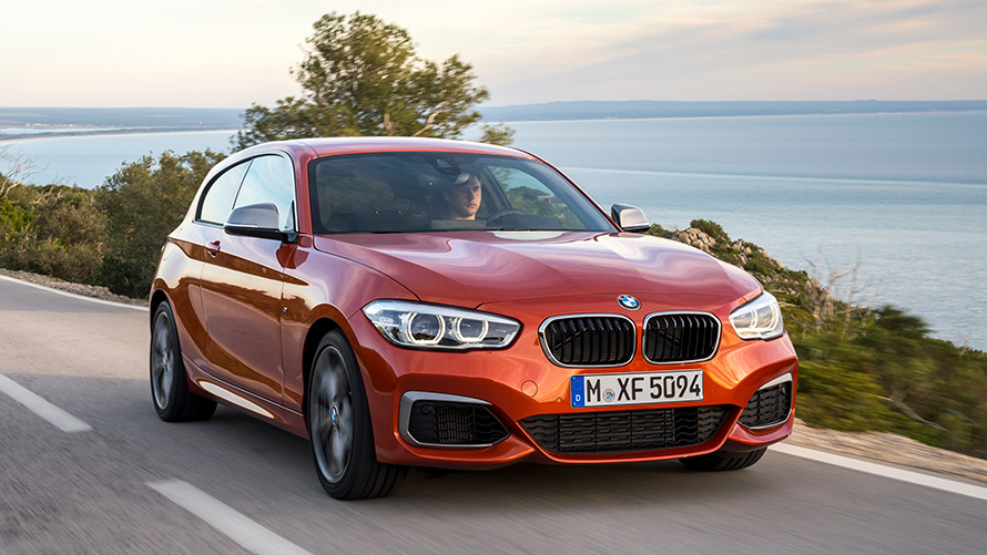 BMW M135i (F21) три четвърти изглед отпред в движение пред езеро и планини BMW M135i (F21) три четвърти изглед отпред в движение пред езеро и планини