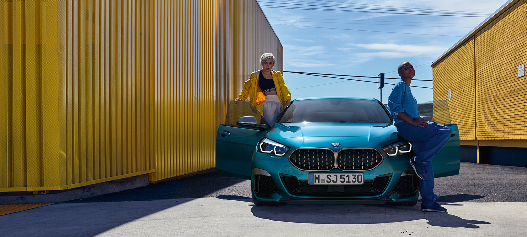BMW Серия 2 Гран Купе F44, изглед отпред BMW Серия 2 Гран Купе F44 F44 Snapper Rocks Blue metallic, изглед отпред с отворени врати и двама човека в автомобила