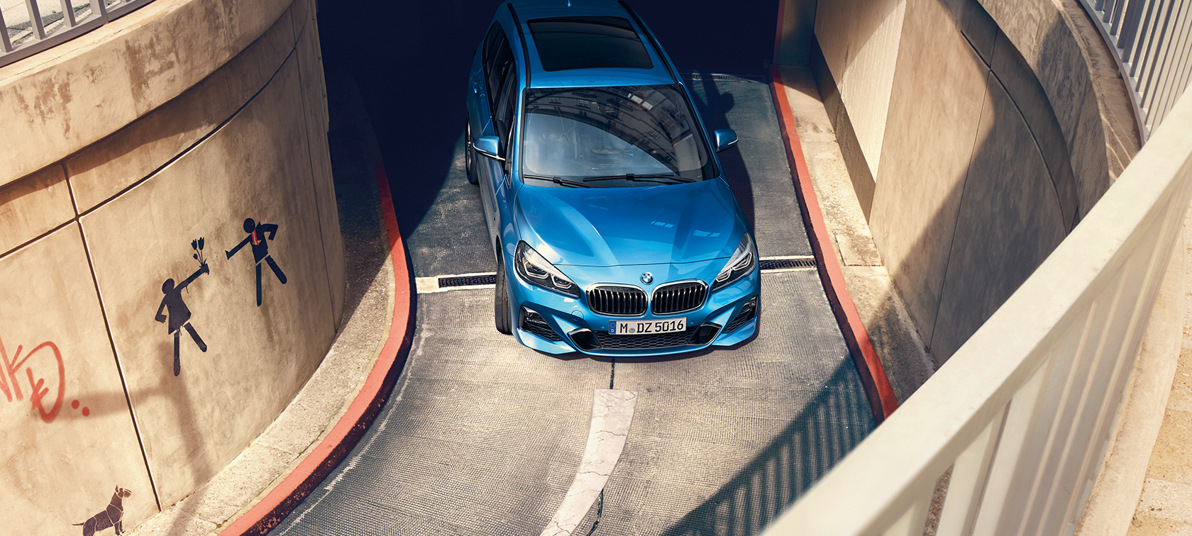 BMW Серия 2 Гран Турър в многоетажен паркинг BMW Серия 2 Гран Турър F46 Estoril Blue metallic от перспектива птичи поглед в движение в многоетажен паркинг