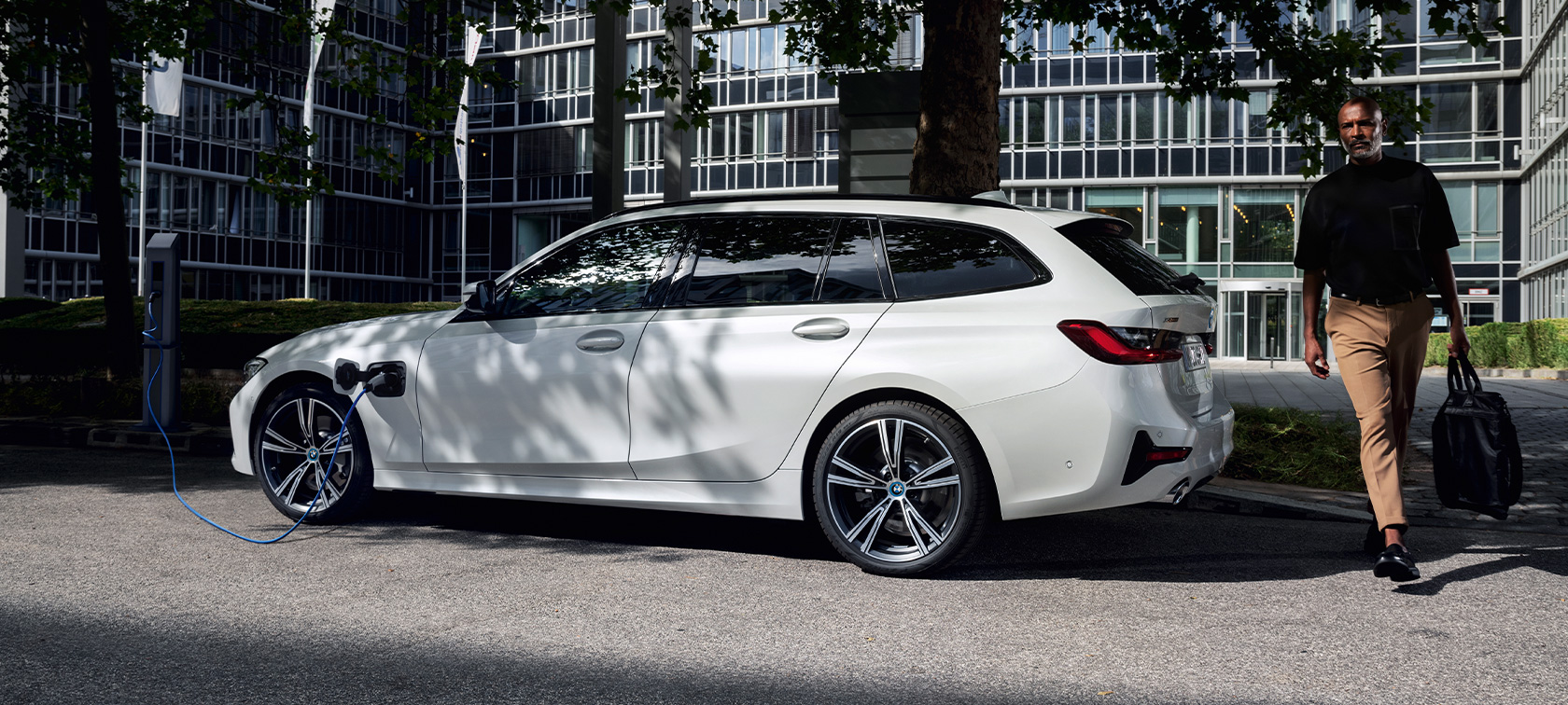 Plug-in хибрид BMW Серия 3 Туринг 2021 G21 три четвърти изглед отстрани при зареждане Plug-in хибрид BMW Серия 3 Туринг 2021 G21 три четвърти изглед отстрани при зареждане, с модел