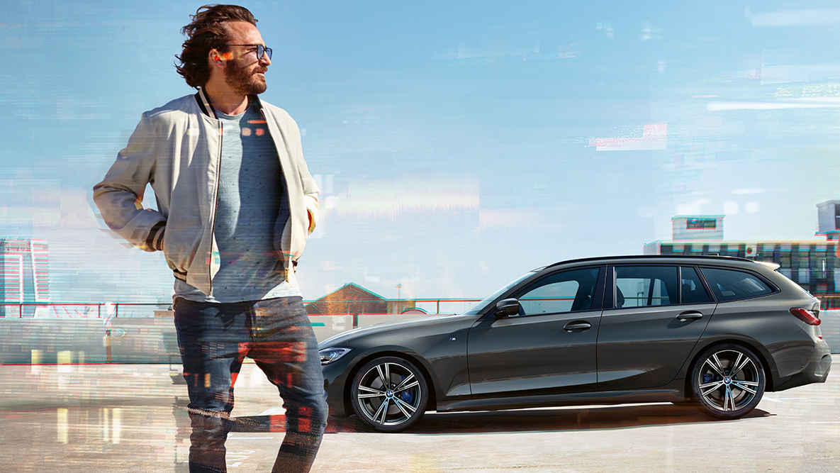 BMW Серия 3 Туринг (G21) три четвърти снимка отпред Дизайн BMW Серия 3 Туринг (G21) Dravite Grey, три четвърти снимка отпред при шофиране по мост сред природата