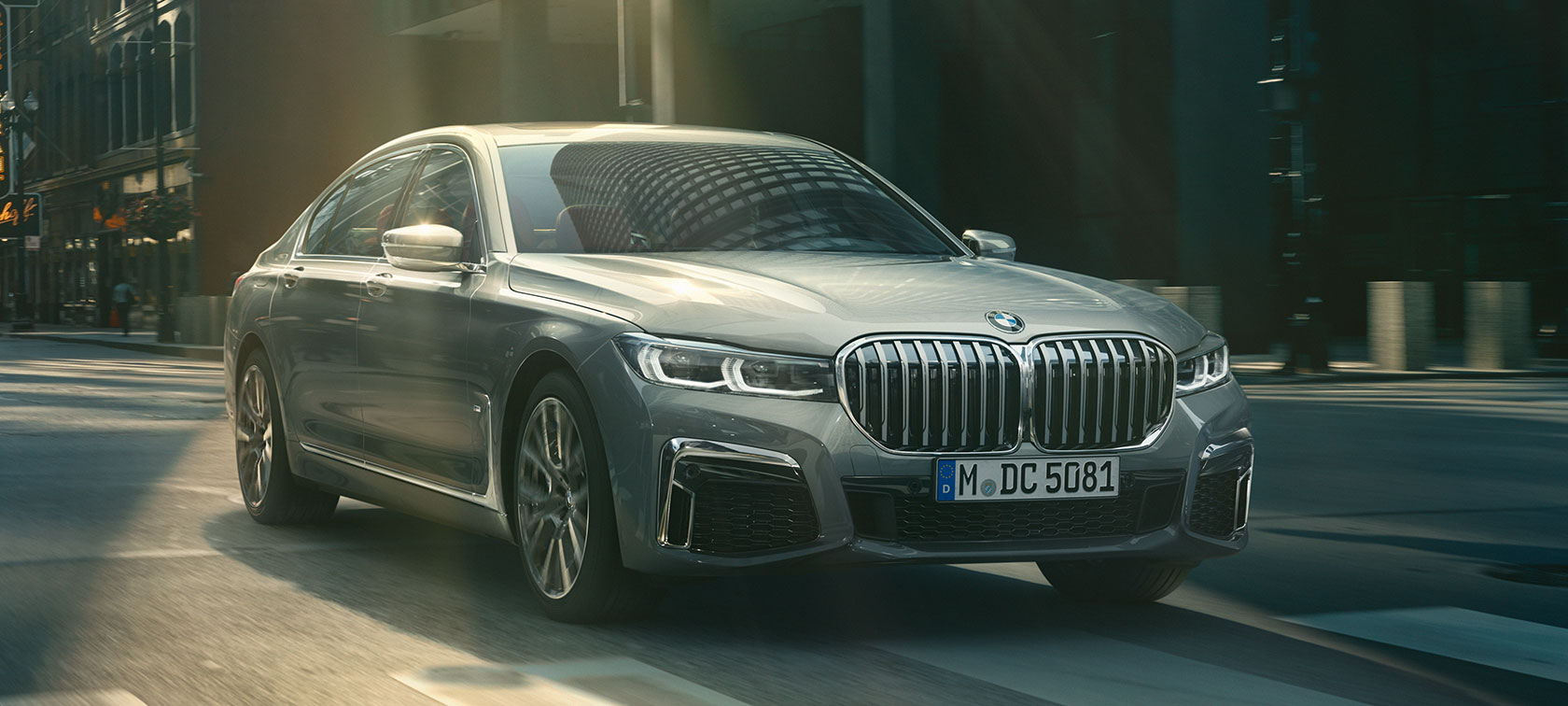 BMW Серия 7 в движение, три четвърти изглед отпред Сиво BMW Серия 7 се движи на фона на града, три четвърти изглед отпред
