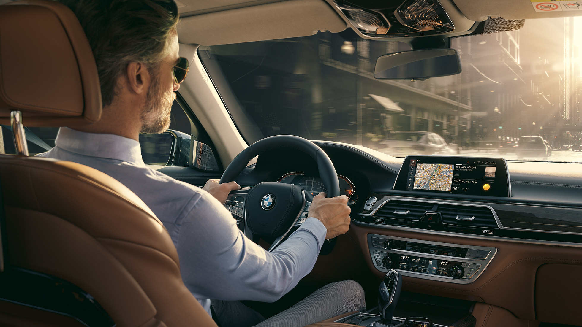 BMW Серия 7 функции за свързаност BMW Серия 7: мъж седи в BMW и ползва функциите за свързаност