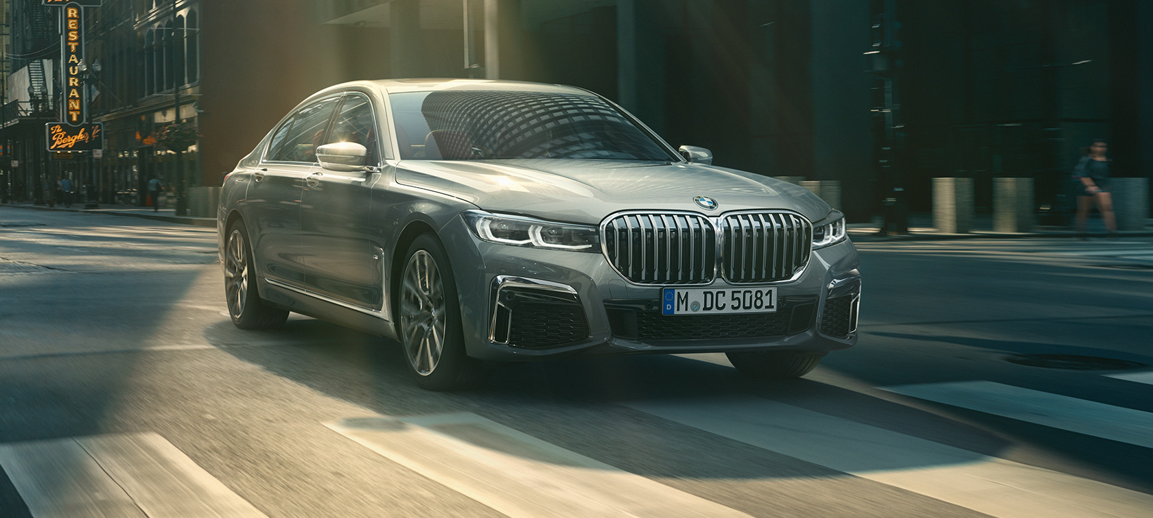 BMW Серия 7 G11 G12 2019 Bernina Grey Amber Effect три четвърти изглед отпред в движение BMW Серия 7 G11 G12 2019 Bernina Grey Amber Effect три четвърти изглед отпред при движение на фона на града