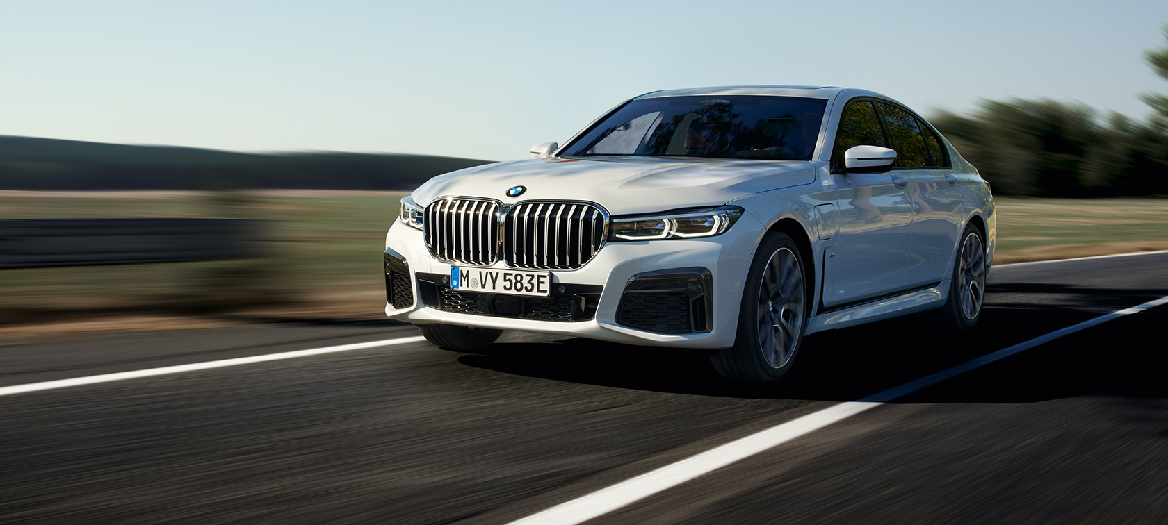 BMW 745e Plug-in хибрид G11 G12 Mineral White metallic три четвърти изглед отпред BMW 745e Plug-in хибрид G11 G12 Mineral White metallic три четвърти изглед отпред в движение по междуградски път