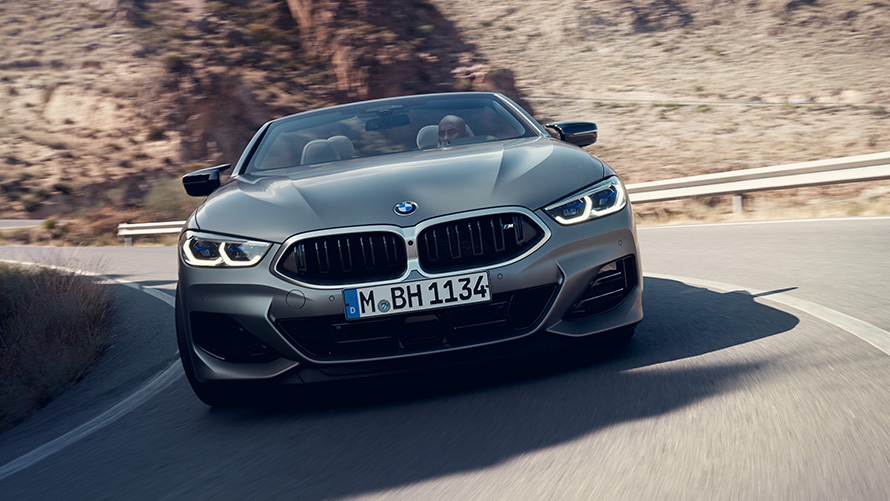Новото BMW Серия 8 Кабриолет M Спортен пакет G14 LCI Facelift 2022 изглед отпред в движение в завой Новото BMW Серия 8 Кабриолет М Спортен пакет G14 LCI Facelift 2022 BMW Individual Frozen Pure Grey metallic изглед отпред в движение в завой