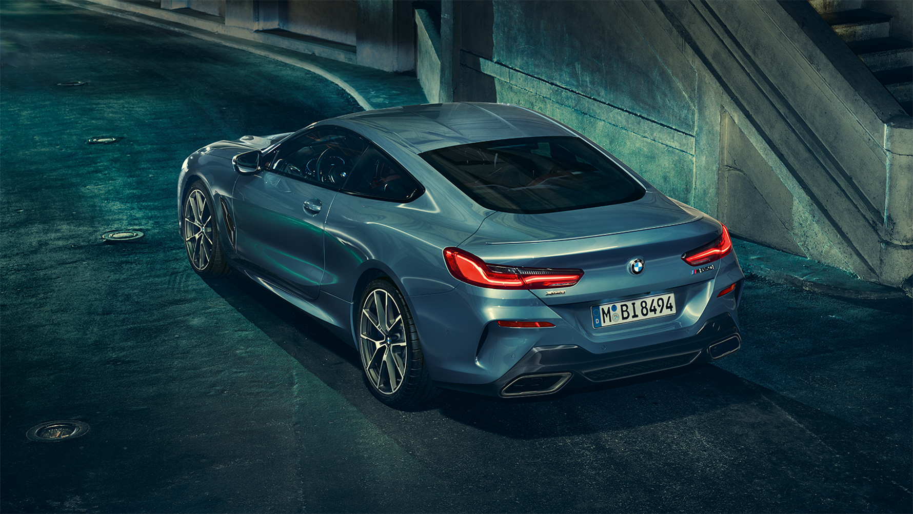 BMW Серия 8 Купе, три/четвърти снимка отзад Три/четвърти снимка отзад на BMW Серия 8 Купе през нощта на фона на града.