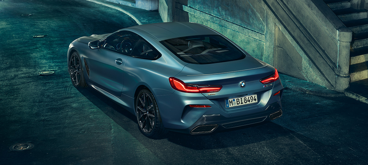 BMW M850i Купе First Edition, три четвърти изглед отпред Три четвърти изглед отзад на BMW M850i Купе First Edition на фона на града