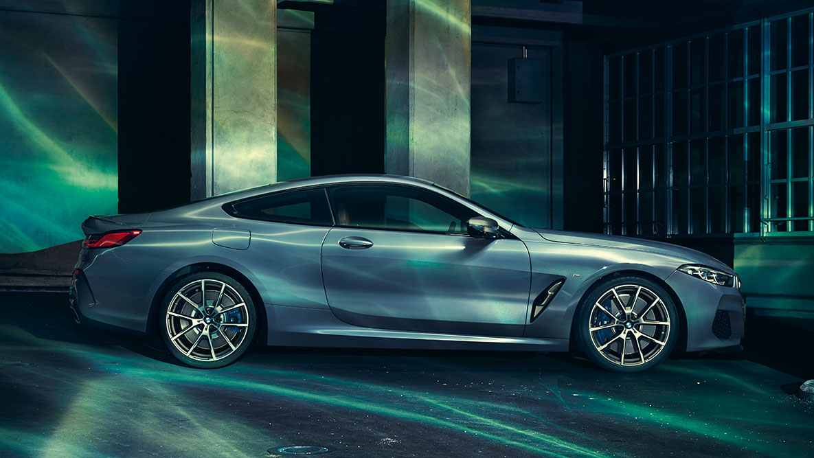 BMW Серия 8 Купе, изглед отстрани. Снимка на BMW Серия 8 Купе в покой отстрани на фона на града.