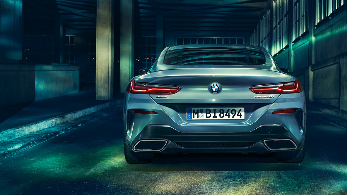 BMW Серия 8 Купе, изглед отзад. Снимка отзад на BMW Серия 8 Купе през нощта на фона на града.
