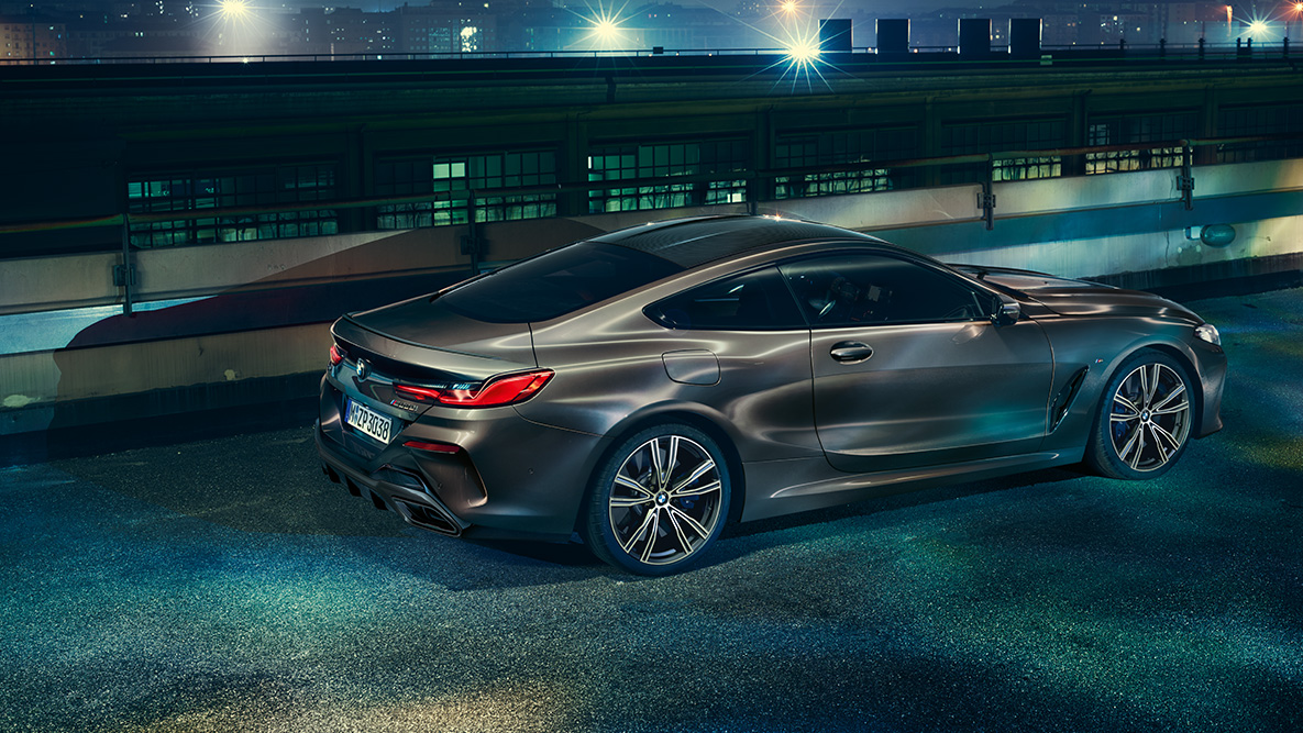 BMW Серия 8 Купе, снимка отстрани в покой. BMW Серия 8 Купе с оборудване BMW Individual, снимка отстрани в покой през нощта на фона на града.