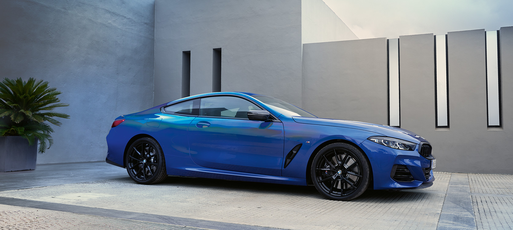 BMW Серия 8 Купе G15 LCI Facelift 2022 М Portimao Blue metallic изглед отстрани пред стена