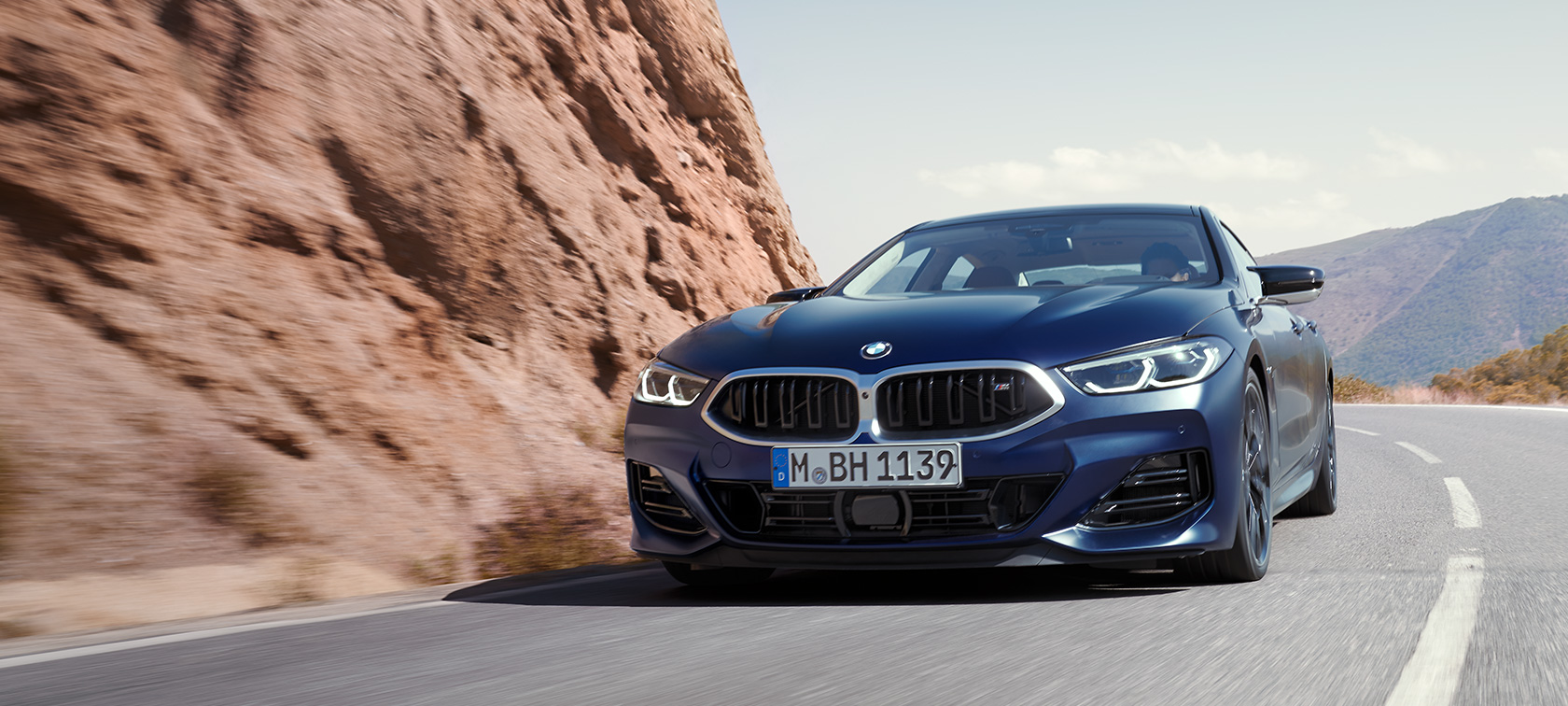 BMW Серия 8 Гран Купе G16 LCI Facelift 2022 BMW Individual Frozen Tansanite Blue metallic три четвърти изглед отпред в движение по планински път