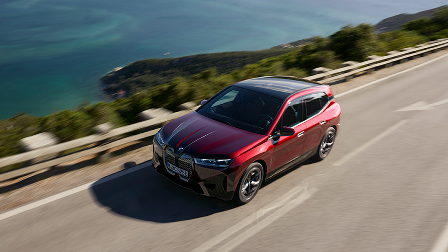 BMW iX i20 електрически SUV BMW iX xDrive50 динамика BMW iX i20 2021 електрически SUV BMW iX xDrive50 Aventurine Red на пътя в движение динамика