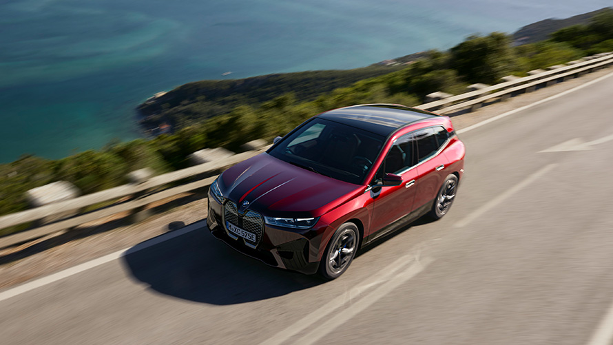 BMW iX i20 електрически SUV BMW iX xDrive50 динамика BMW iX i20 2021 електрически SUV BMW iX xDrive50 Aventurine Red на пътя в движение динамика