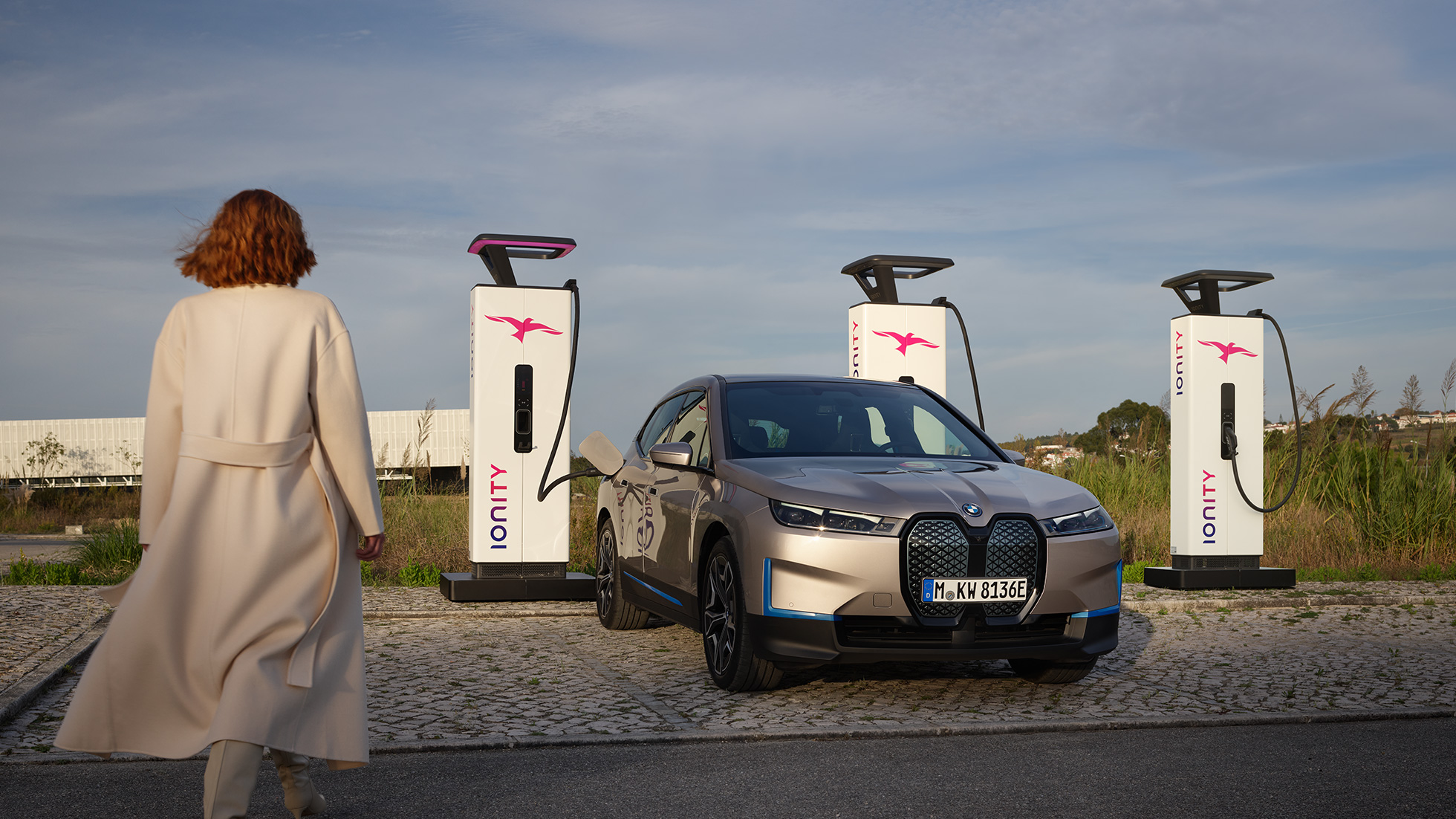 BMW iX три четвърти изглед отпред на зарядна станция BMW iX Cashmere Silver i20 три четвърти изглед отпред на зарядна станция