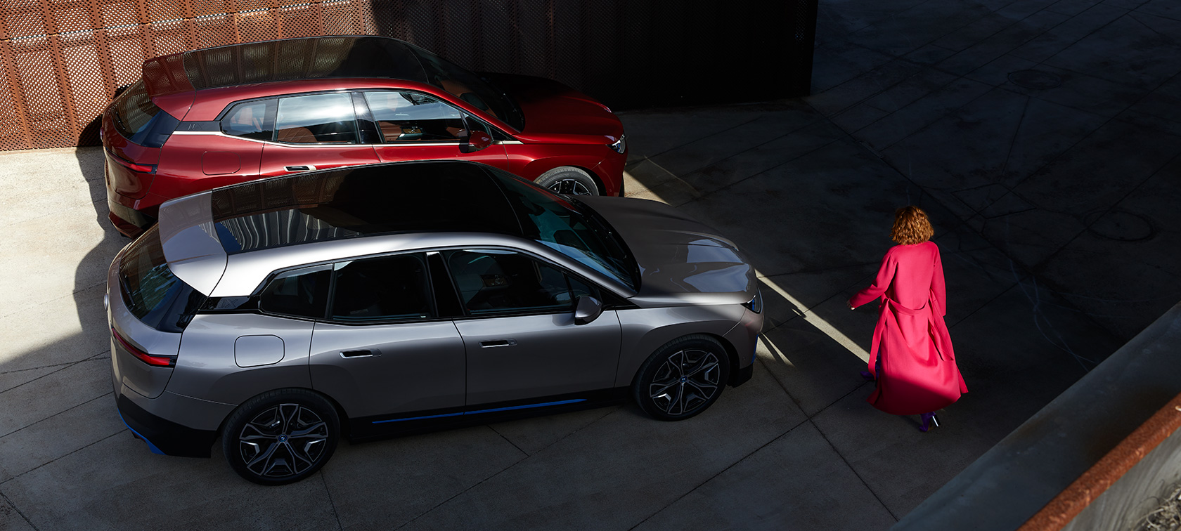 BMW iX от перспектива птичи поглед с модел BMW iX Aventurin Red и Cashmere Silver i20 от перспектива птичи поглед с модел