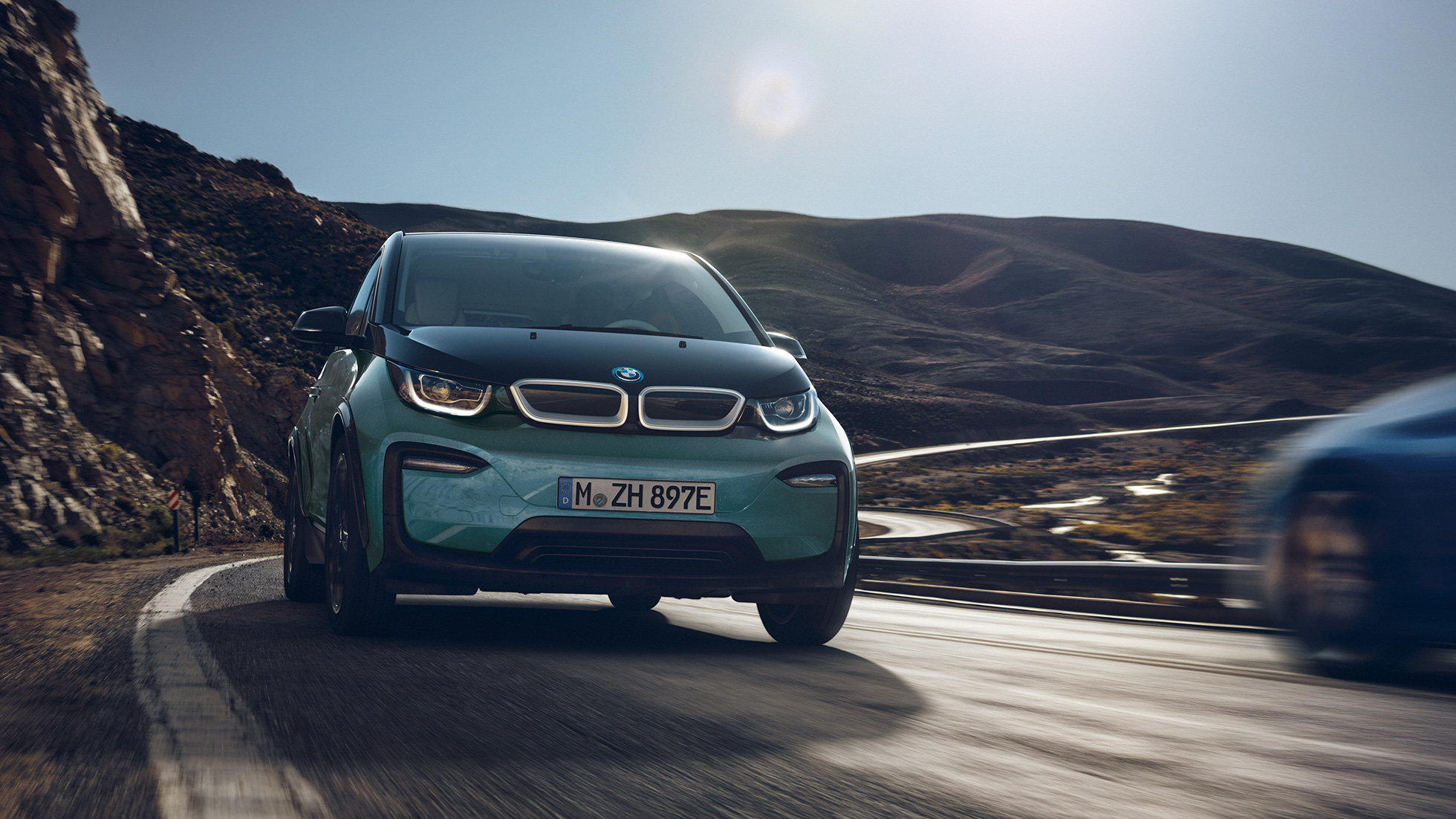 BMW i3 2018 изглед отстрани, в движение BMW i3 I01 2018 Jucaro Beige с акцент Frozen Grey metallic изглед отстрани, в движение на фона на града