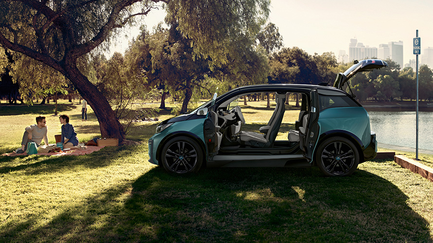 BMW i3 2018 в парк BMW i3 I01 2018 Jucaro Beige с акцент Frozen Grey metallic изглед отстрани с отворени врати в парк