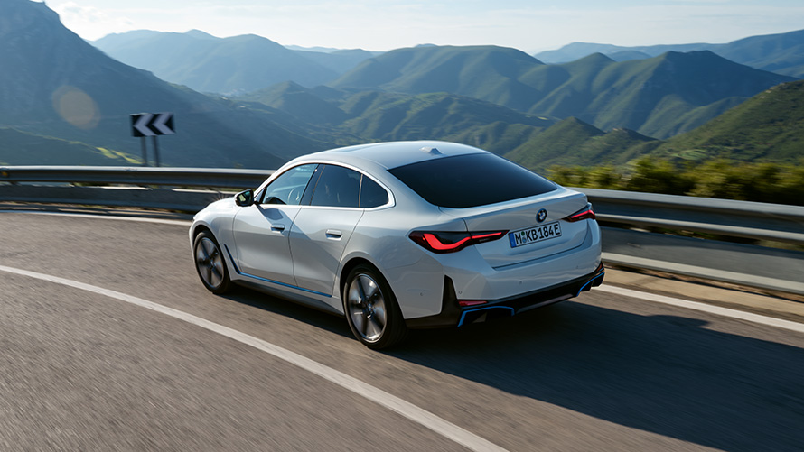 Три четвърти изглед отзад BMW i4 eDrive40 G26 2021 в движение BMW i4 eDrive40 G26 2021 Mineral White три четвърти изглед отзад в движение