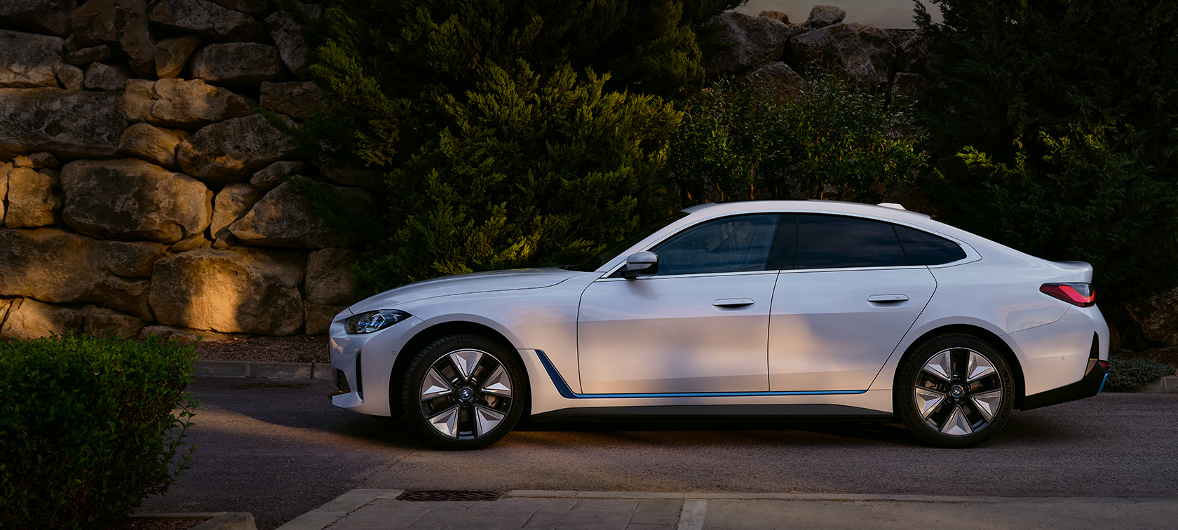 BMW i4 eDrive40 G26 2021 Mineral White три четвърти изглед отпред в покой пред езеро на фона на хълмове 