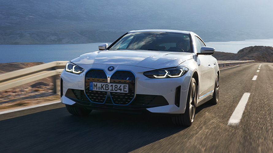 Три четвърти изглед отпред BMW i4 eDrive40 G26 2021 в движение BMW i4 eDrive40 G26 2021 Mineral White три четвърти изглед отпред в движение