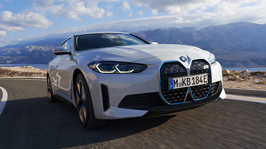 Три четвърти изглед отпред BMW i4 eDrive40 G26 2021 в движение BMW i4 eDrive40 G26 2021 Mineral White три четвърти изглед отпред в движение