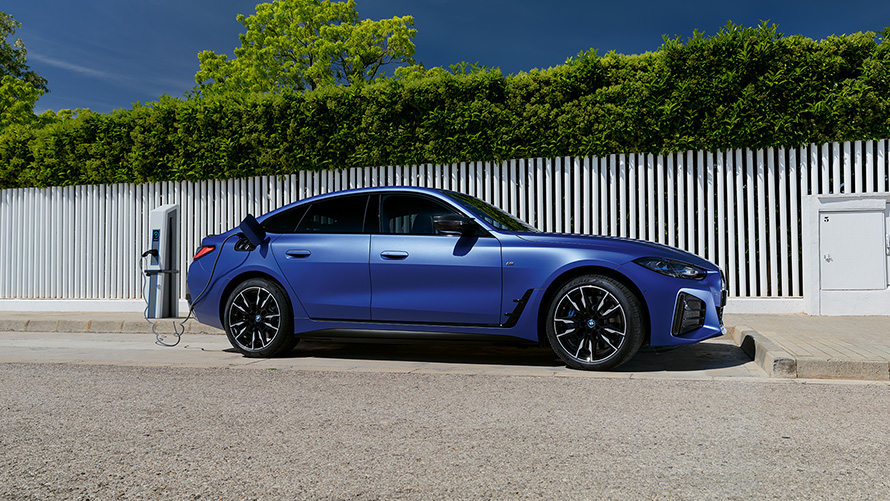 BMW i4 M50 G26 2021 BMW Individual Frozen Portimao Blue metallic изглед отстрани свързано със зарядна станция