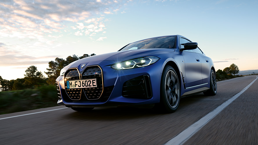 Три четвърти изглед отпред BMW i4 M50 G26 2021 от ниска гледна точка BMW i4 M50 G26 2021 BMW Individual Frozen Portimao Blue metallic три четвърти изглед отпред в движение от ниска гледна точка